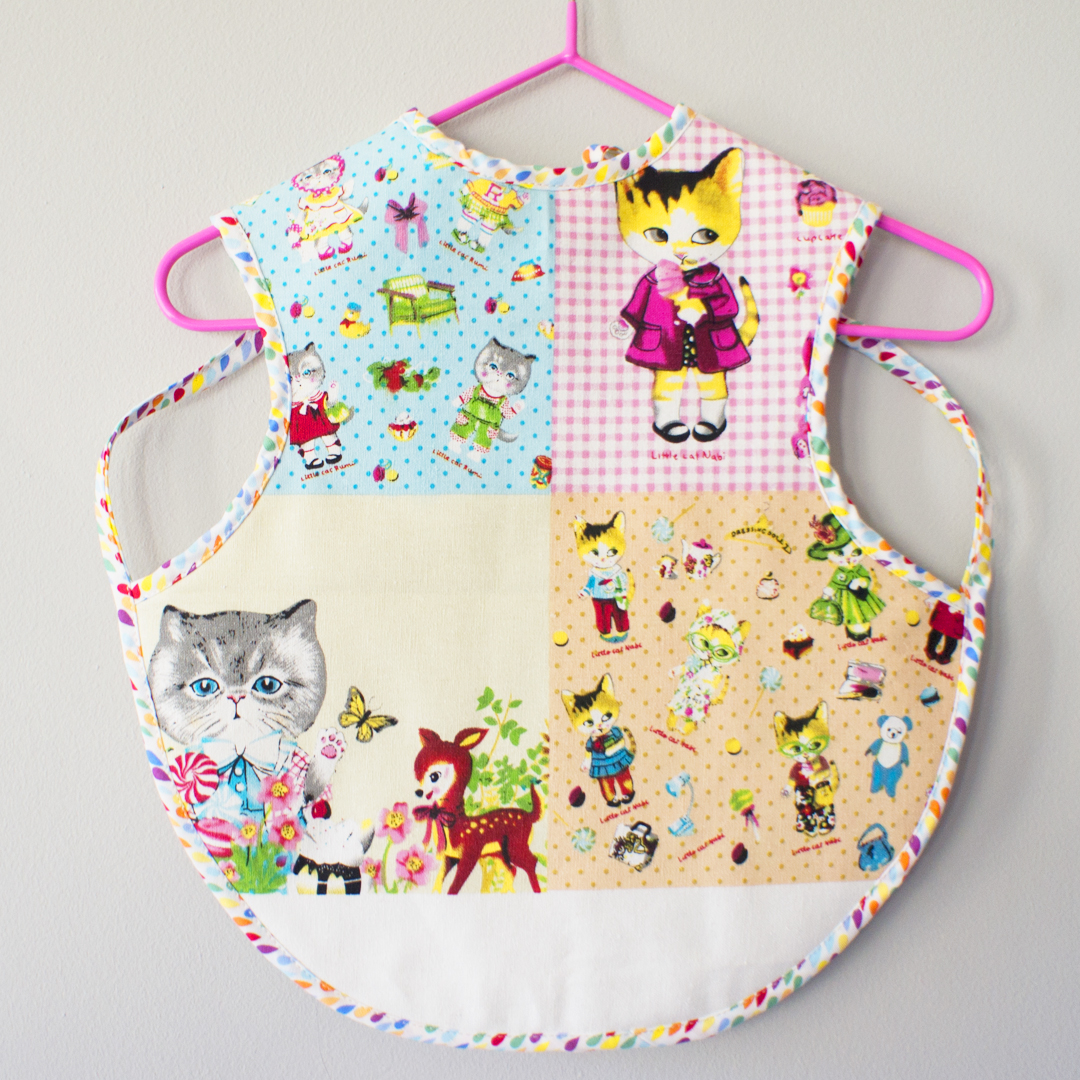 Baby bib apron with cat print cotton linen front with absorbent felt back suitable for children aged 6 months to 4 years old.